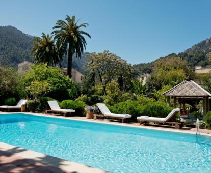 Hermosos exteriores con piscina rodeada de vegetación de este hotel con encanto.