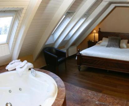 Suite con bañera de hidromasaje cerca de la cama de este coqueto hotel con encanto.