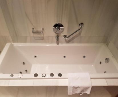 Bañera de hidromasaje privada en el baño de habitación deluxe del hotel.