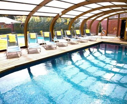 Gran piscina cubierta con tumbonas y hermosas vistas de este hotel con encanto.