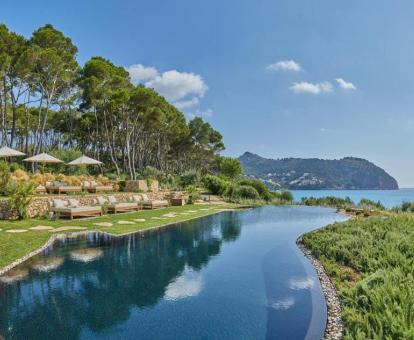 Gran piscina en la naturaleza con vistas al mar de este hotel con encanto.