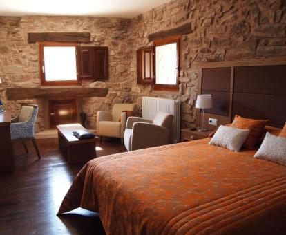 Una de las habitaciones con paredes de piedra y sala de estar de este hotel rural.
