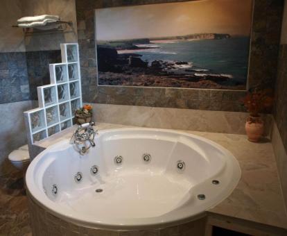 Baño con bañera de hidromasaje privada de la habitación superior dúplex del hotel. 