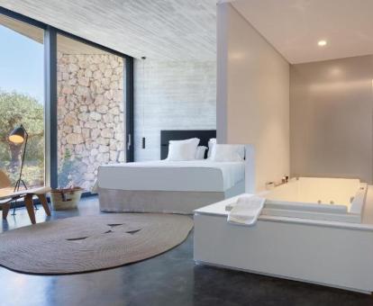 Dormitorio con bañera de hidromasaje privada de la suite con piscina privada del hotel. 