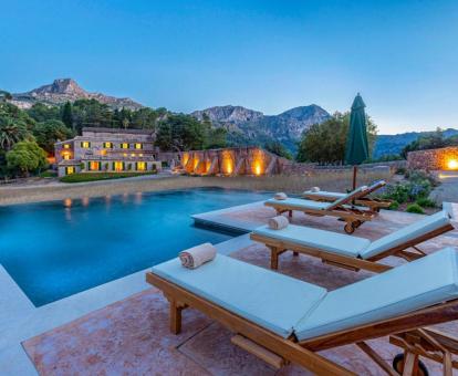 Hermoso hotel rural rodeado de montañas con gran piscina al aire libre.