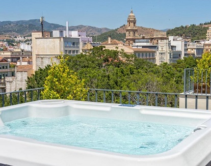 Foto del jacuzzi con chorros de hidromasaje en la terraza con la ciudad de Málaga al fondo