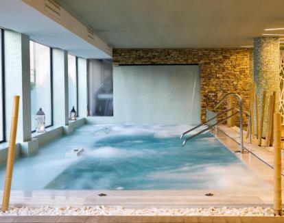 Foto del spa del hotel con piscina dinámica y jacuzzi.
