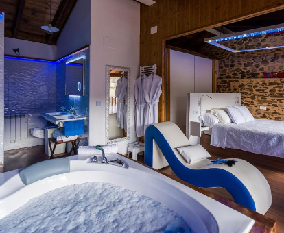Foto de la habitación con bañera de hidromasaje al lado de la cama que se encuentra en la Suite rural Nido Azul II