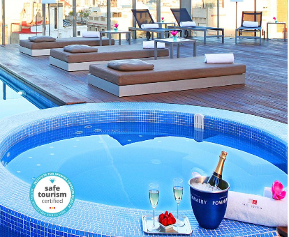 Foto del jacuzzi con chorros de agua y una piscina al aire libre con tumbonas en el hotel solo para adultos Axel Hotel Barcelona