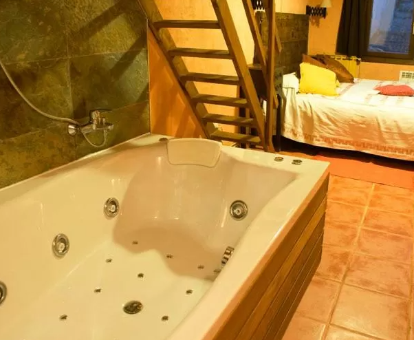 Foto de la habitación con bañera de hidromasaje al lado de la cama de la casa El Rincón de Monasterio
