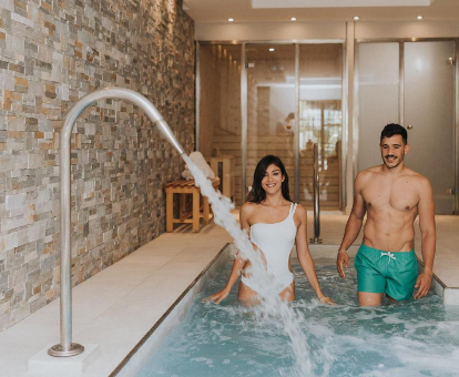 Foto de una pareja entrando en la piscina de hidromasaje del hotel TRH Mijas
