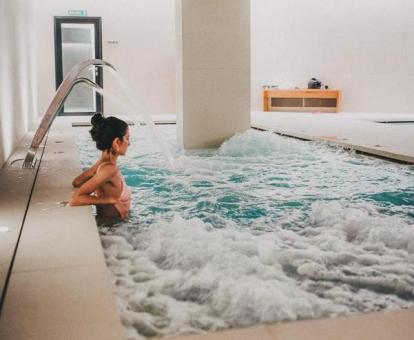 Mujer disfruta de la piscina de hidroterapia del centro de bienestar del hotel.