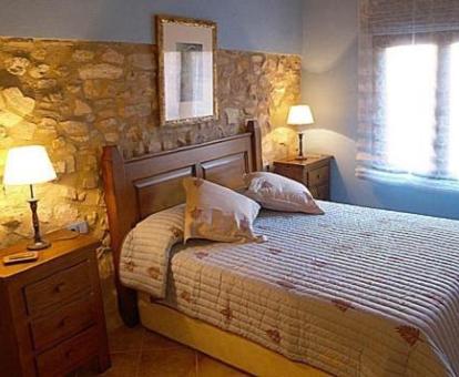 Una de las coquetas habitaciones con paredes de piedra a la vista de este hotel rural.