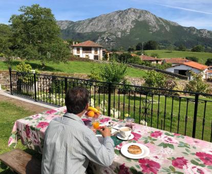Un hombre disfruta de su desayuno en la terraza de este hermoso hotel con espectaculares vistas a la naturaleza.