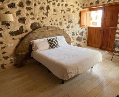 Preciosa habitación de estilo rústico con paredes de piedra a la vista de este alojamiento.