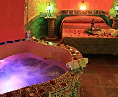 Preciosa Suite Cueva con bañera de hidromasaje privada cerca de la cama.