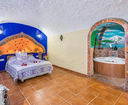 Dormitorio de una de las preciosas casas cueva con bañera de hidromasaje privada del alojamiento.