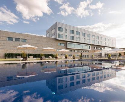 Edificio de este hotel con una gran piscina al aire libre.