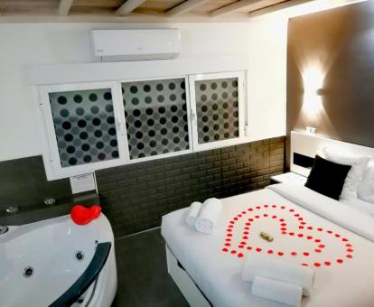 Dormitorio con jacuzzi privado junto a la cama de este coqueto loft para parejas.