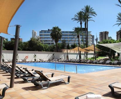 Amplia zona exterior con piscina rodeada de tumbonas de este hotel con encanto.