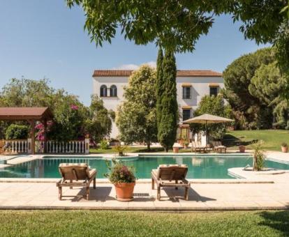 Hotel con encanto rodeado de jardines con amplia piscina exterior.