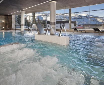Gran piscina con elementos de hidroterapia y preciosas vistas al paisaje nevado que rodea el hotel.