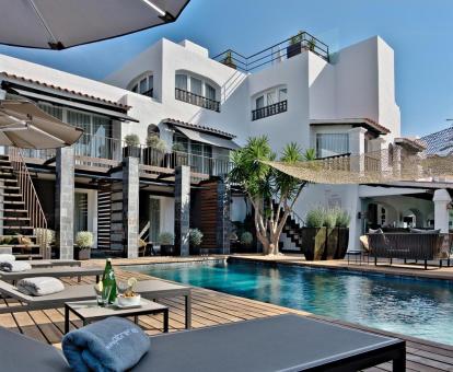 Precioso hotel con encanto con piscina y mobiliario al aire libre.