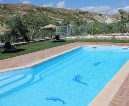 Zona exterior ajardinada con piscina y vistas a la naturaleza de este hotel con encanto.